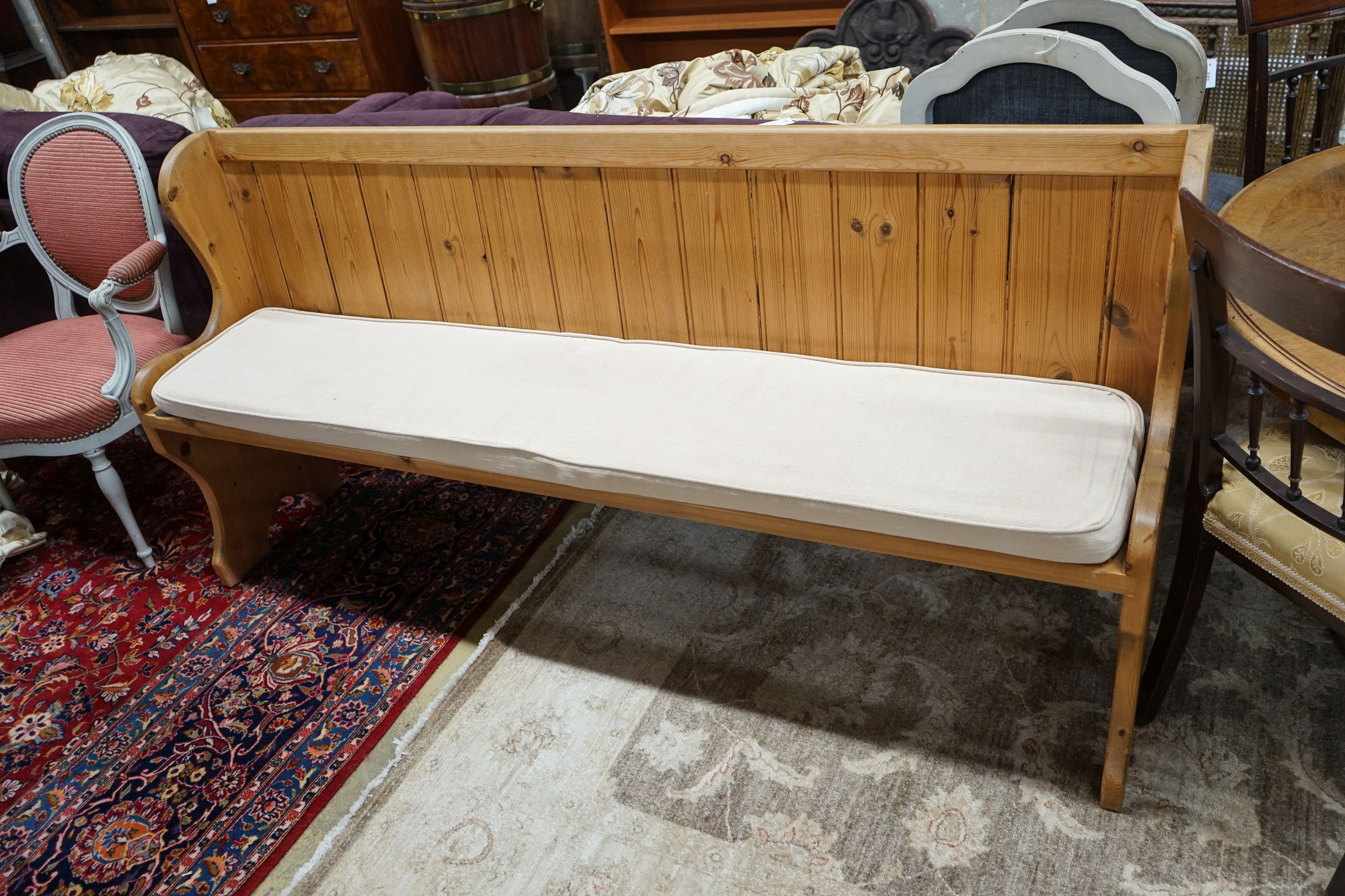 A Victorian style pitch pine pew with cushion seat, length 187cm, depth 40cm, height 88cm